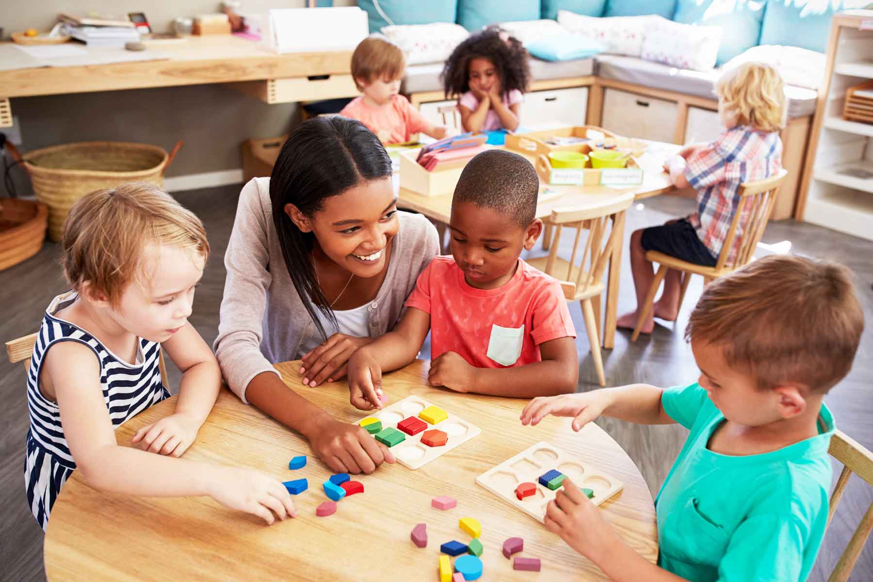 A teacher helping children in preschool.