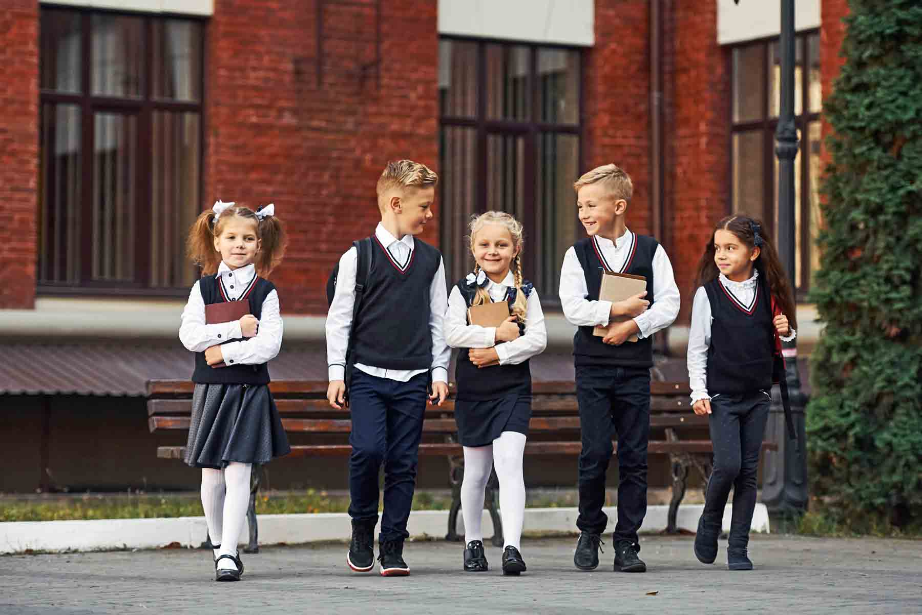 Children in their private school uniforms in front of a school building