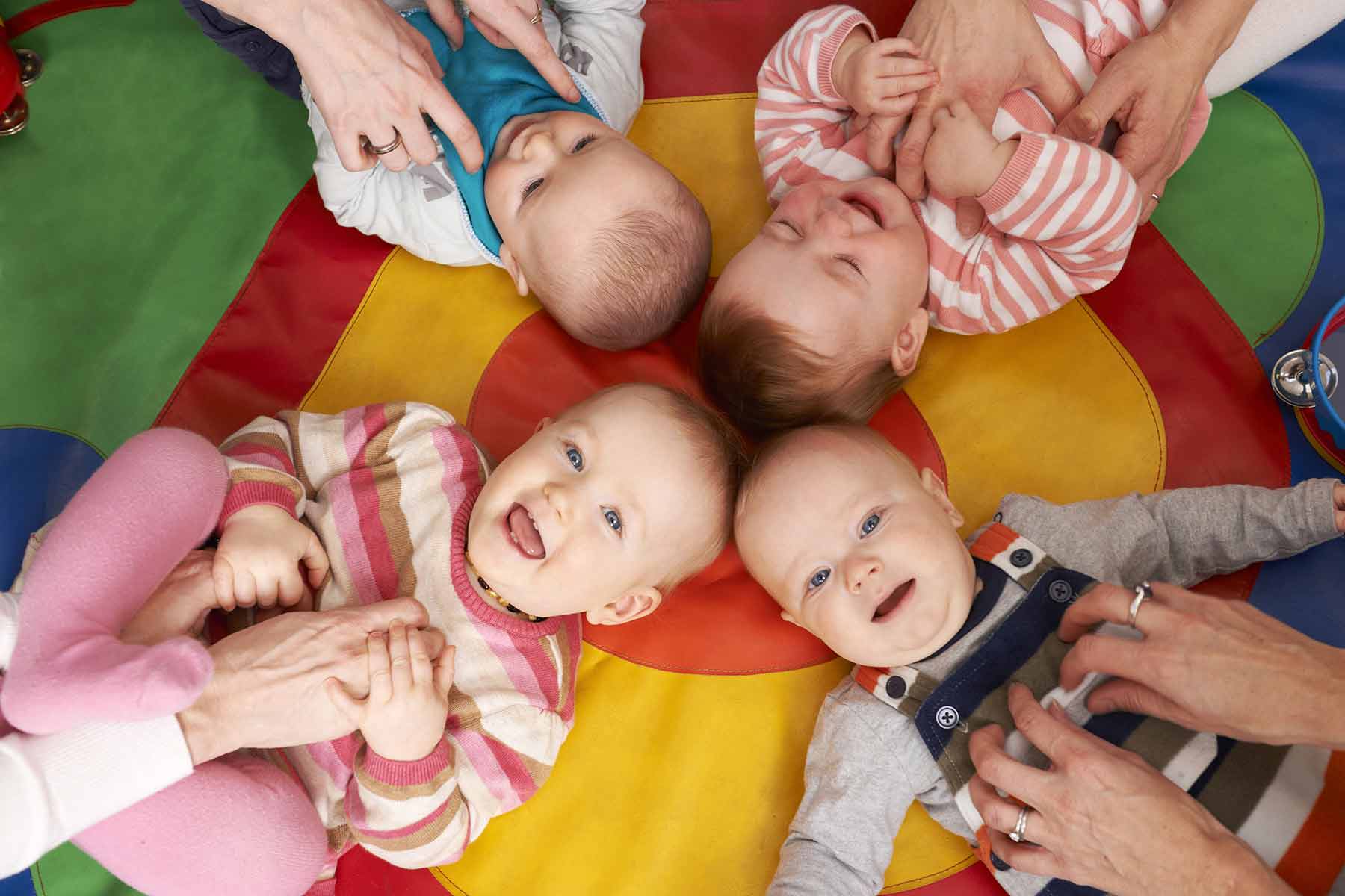 Overhead view of babies having fun at daycare nursery playgroup Overhead view of babies having fun at daycare nursery playgroup