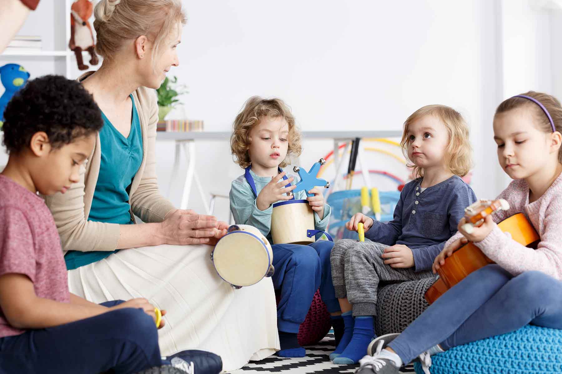 Daycare children having fun playing instruments with their teacher Daycare children having fun playing instruments with their teacher
