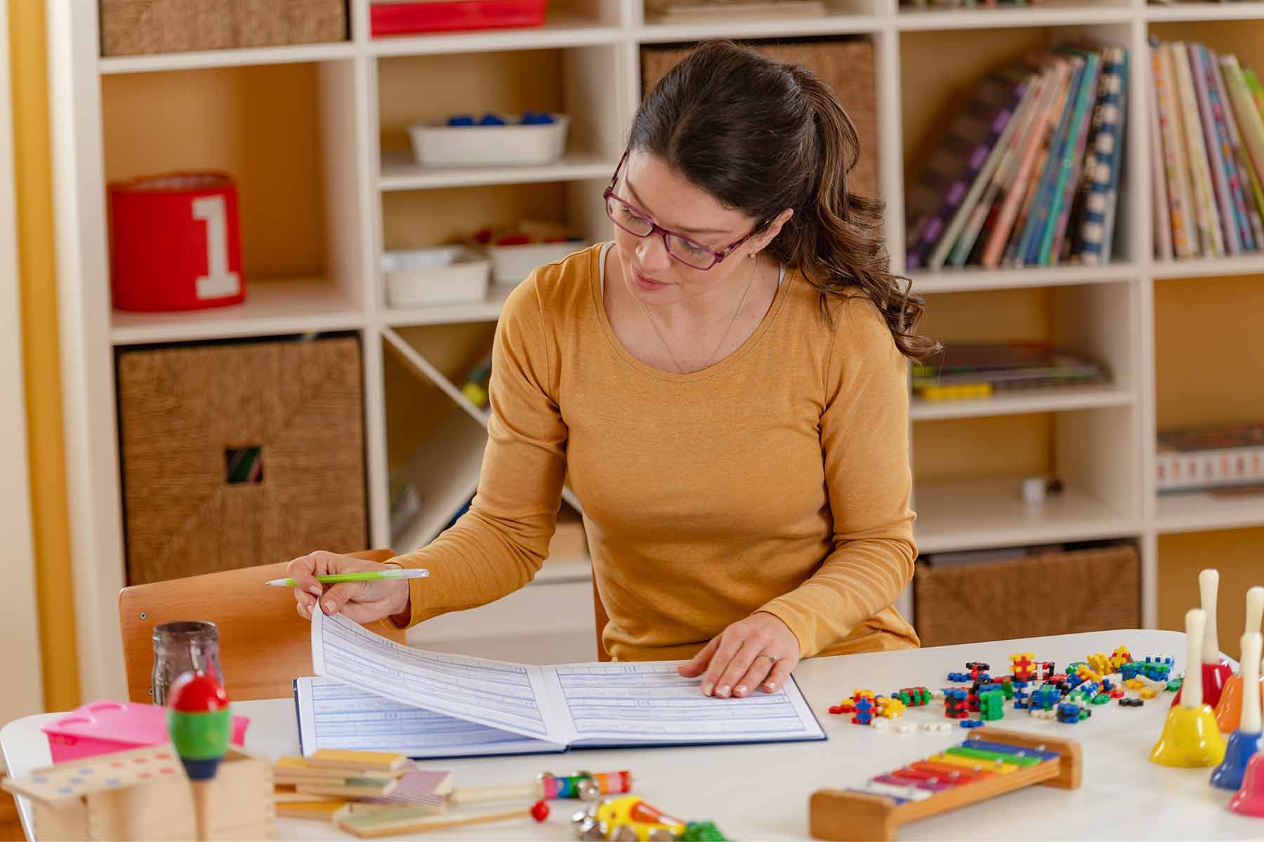 A daycare director reviewing a lesson plan in a childcare classroom A daycare director reviewing a lesson plan in a childcare classroom
