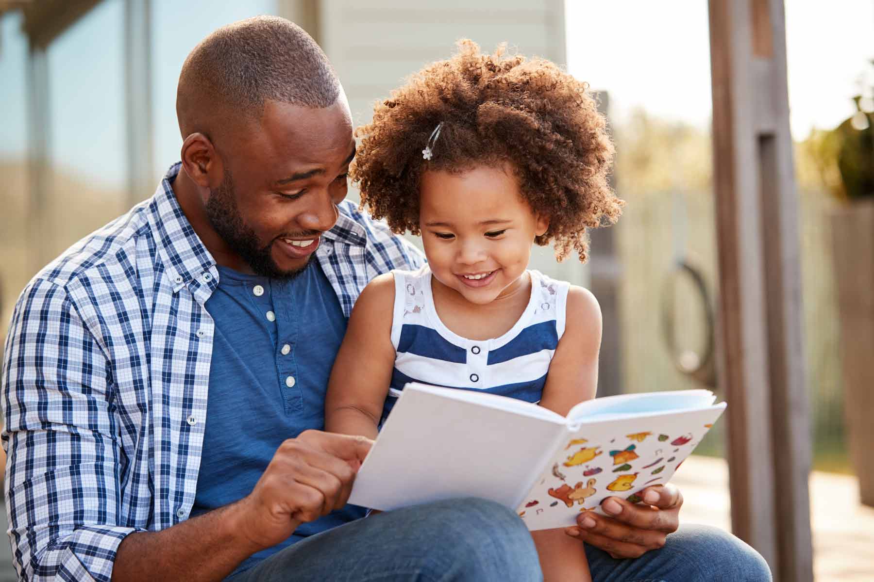 A father and daughter reading a book together