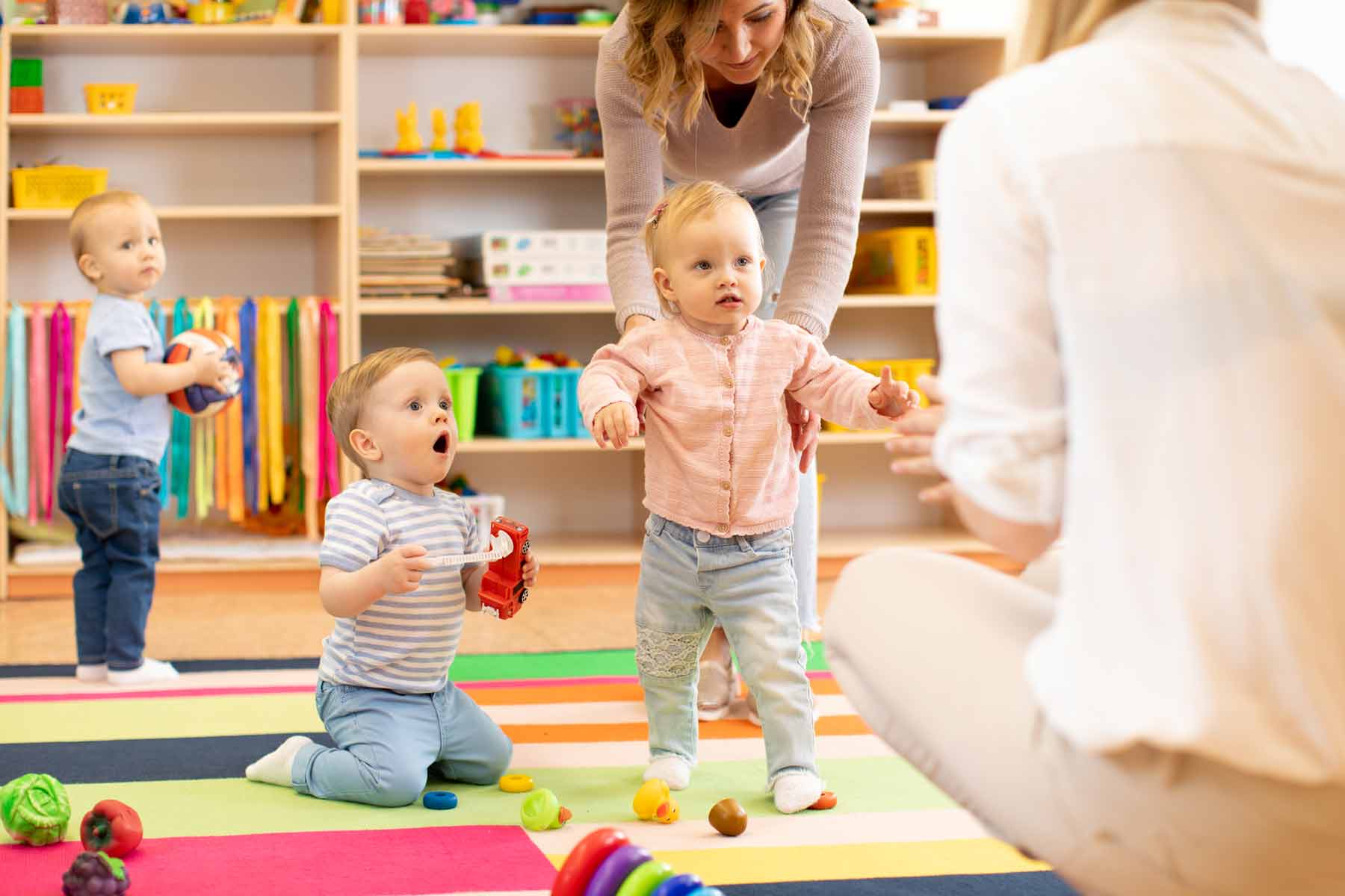 Daycare workers playing with infants and toddlers at a childcare center Daycare workers playing with infants and toddlers at a childcare center