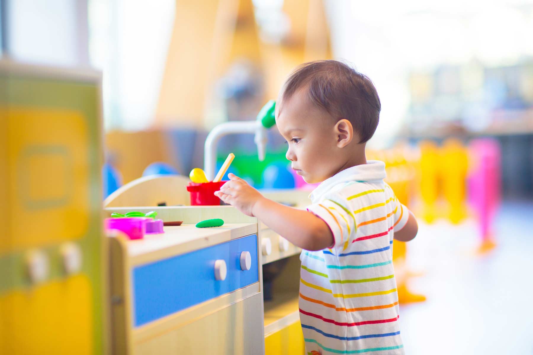 A little boy playing with colorful toys at a daycare center