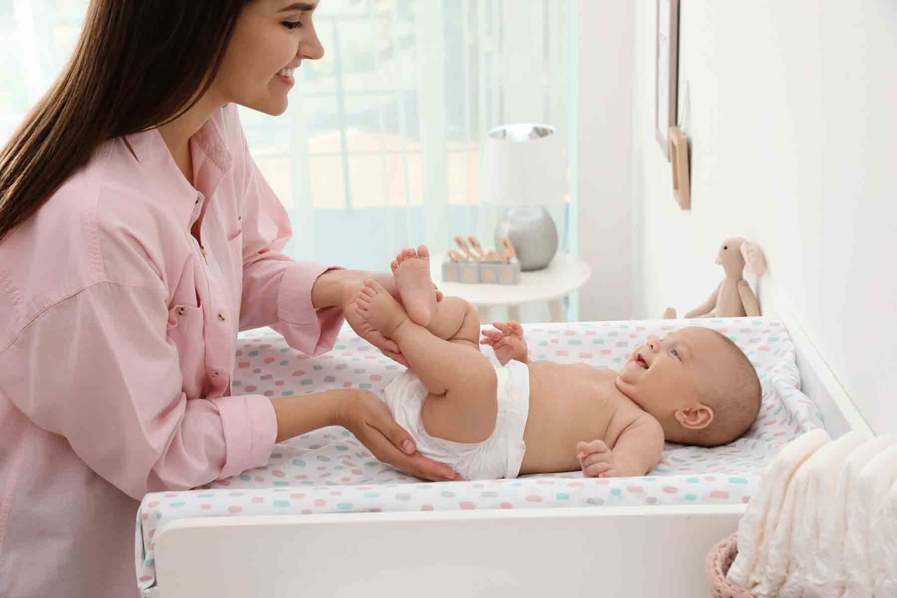 A mother changing her baby's diaper