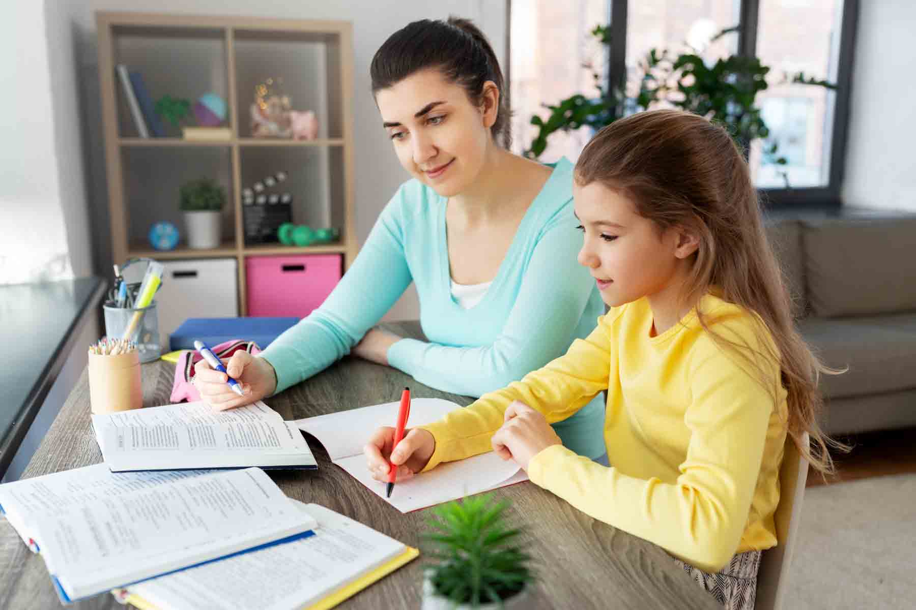 A mother teaching her daughter while homeschooling.