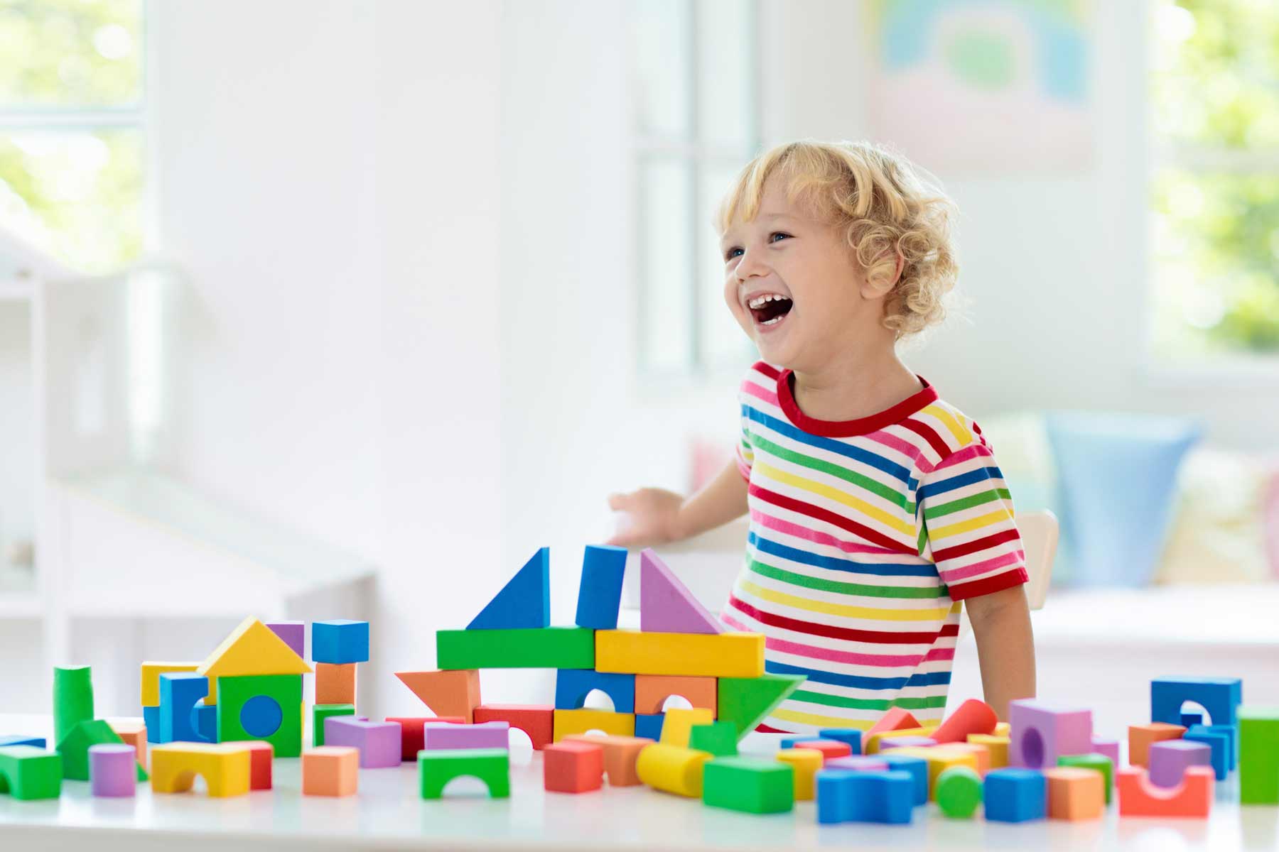 A smiling child playing with blocks at a daycare center