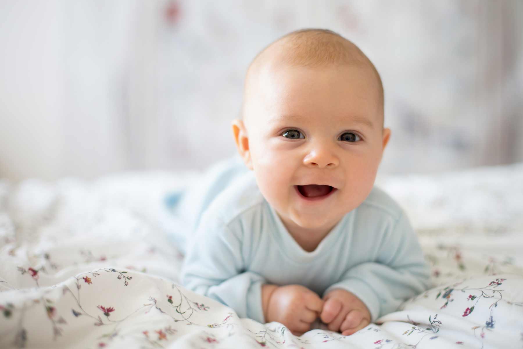 Smiling, happy baby boy lying on a blanket