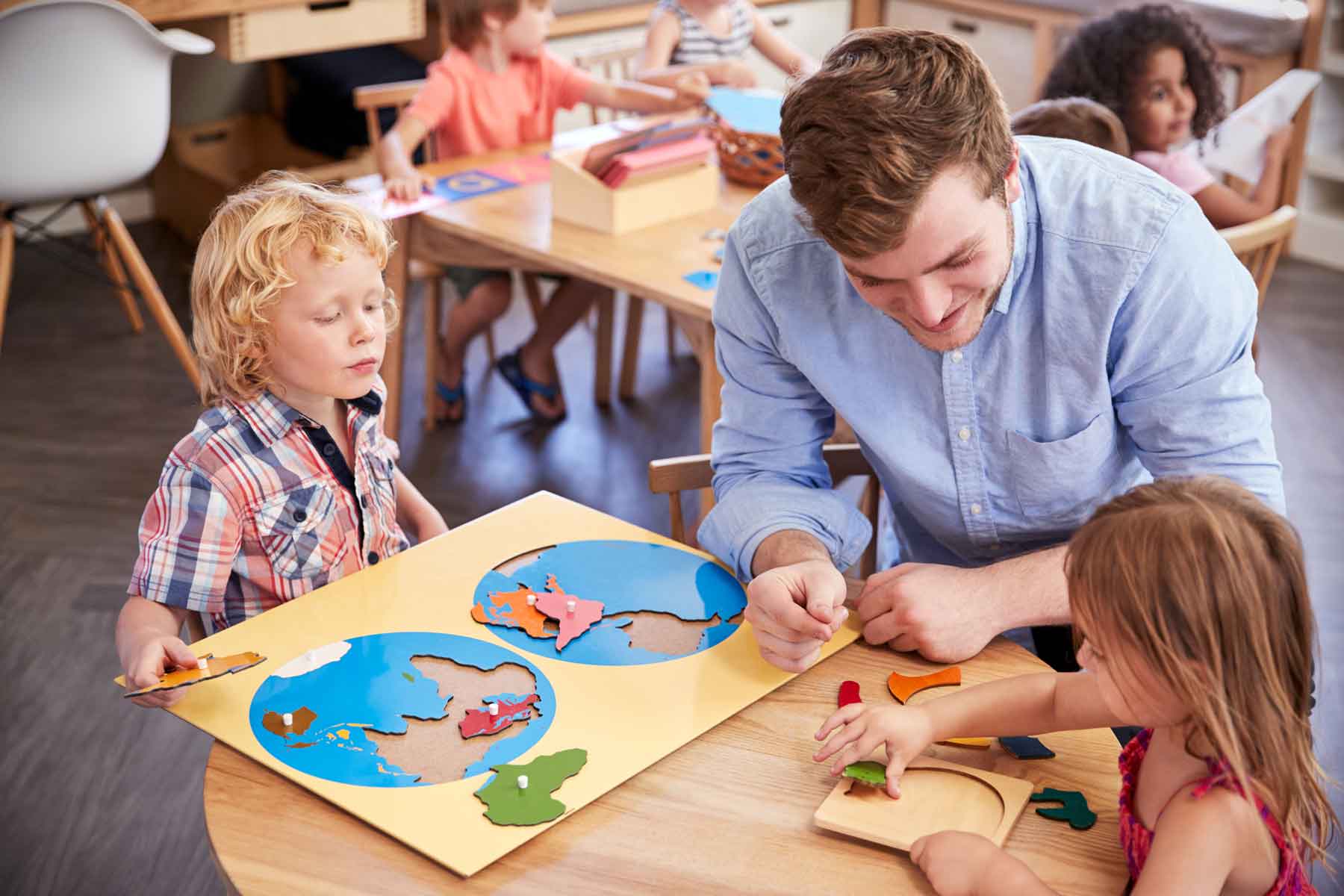 A teacher working with students in a Montessori school