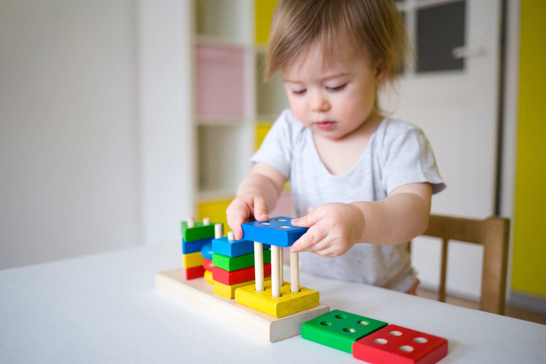 A young child playing with toy blocks to develop motor skills A young child playing with toy blocks to develop motor skills